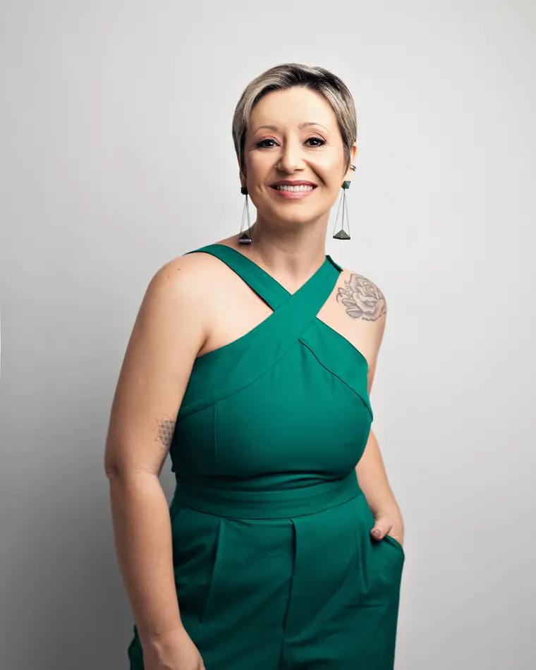 Tatti Santos de macacão verde, sorrindo